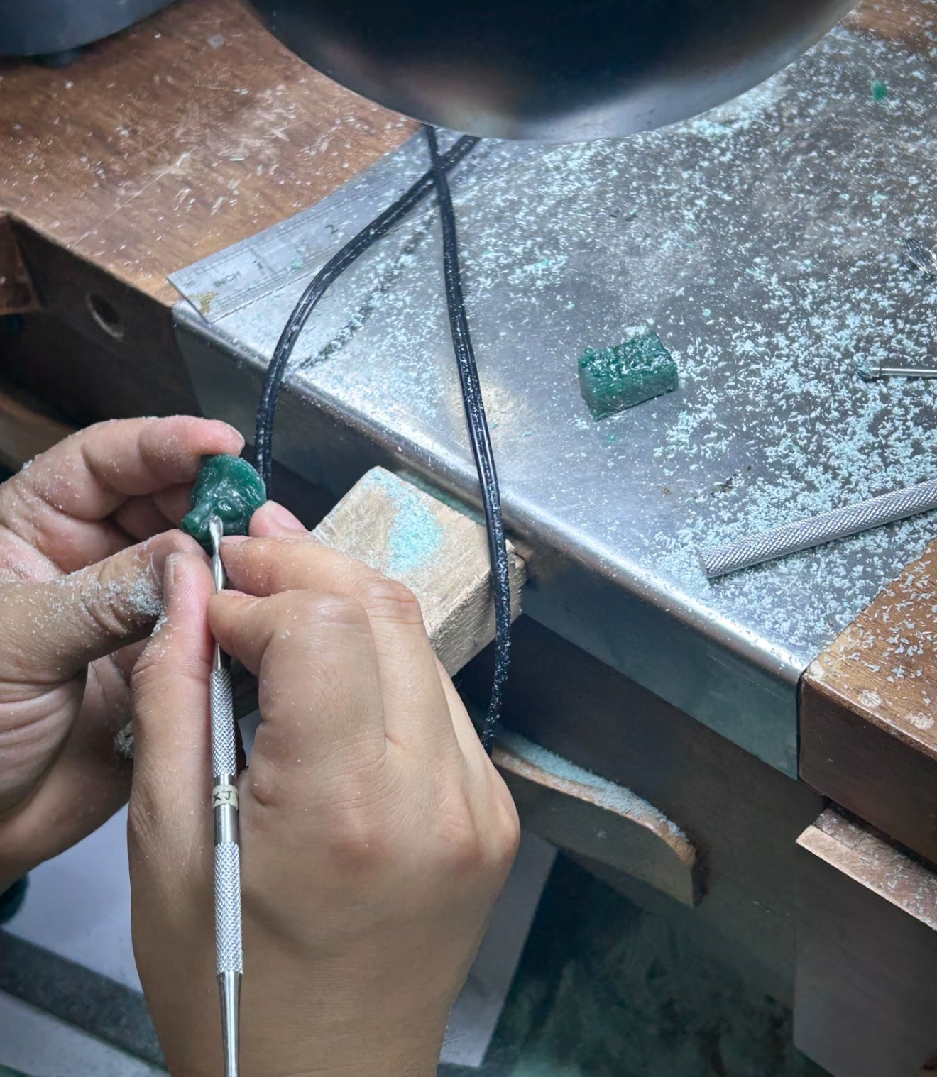 A wax model being shaped by hand at a Julysnow workbench
