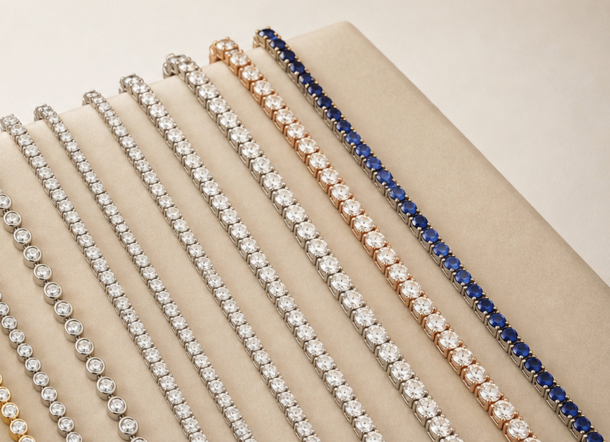 Tennis bracelet styles arranged on a cream jewelry display